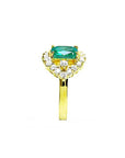 A Muzo colombian emerald ring displaying the top center piece, a halo diamond and the band in yellow gold.