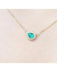 Vibrant pear-shaped emerald necklace with diamond halo on a delicate 14K yellow gold chain.