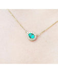 Vibrant pear-shaped emerald necklace with diamond halo on a delicate 14K yellow gold chain.