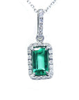 Natural Muzo emerald pendant with diamond accents on a topside view.