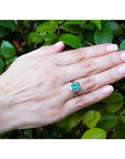 1.50 carat Muzo Colombian emerald solitaire ring in 18K white gold on a hand.