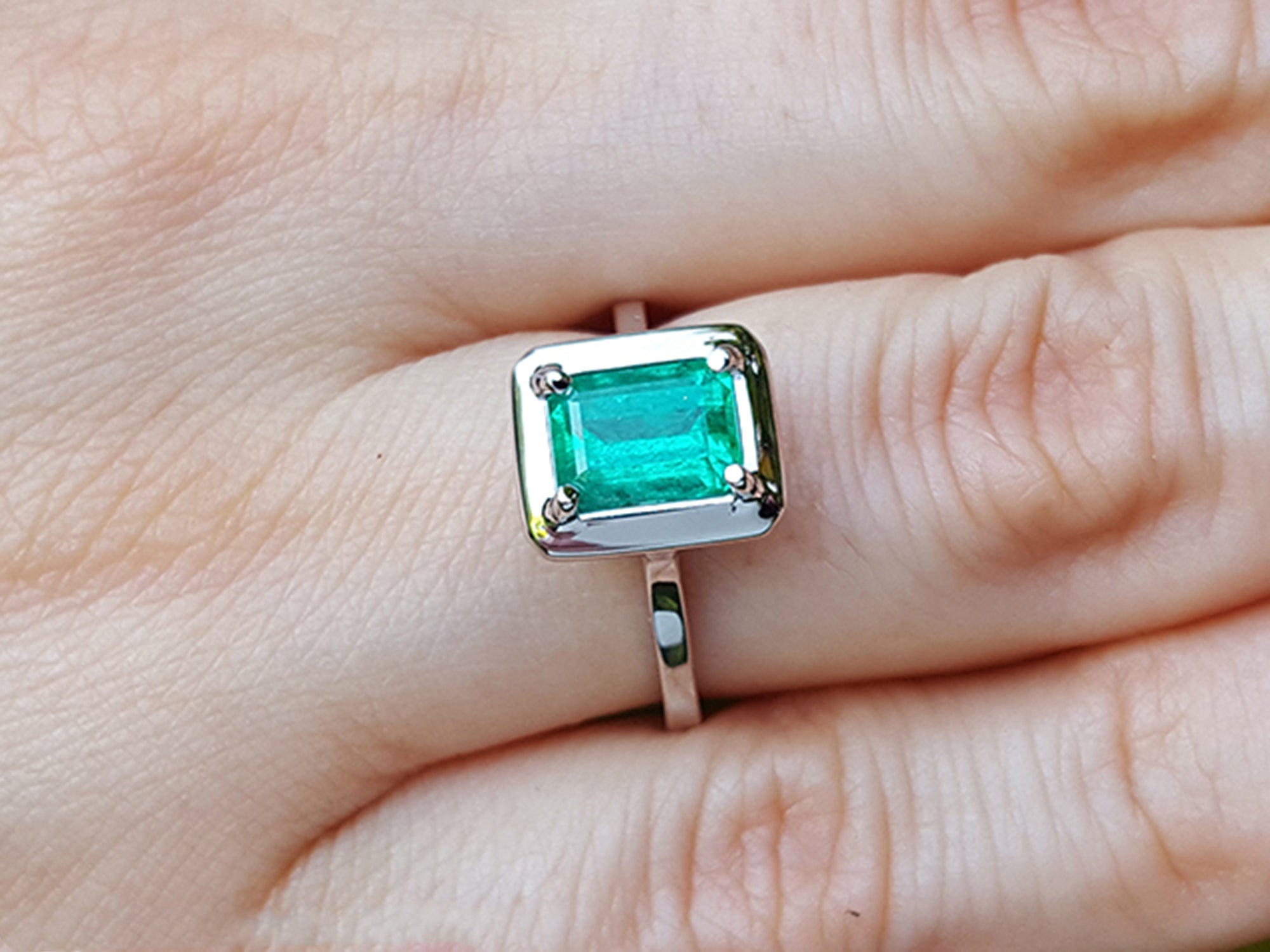 Emerald ring on a finger