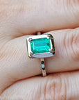 Emerald ring on a finger
