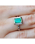 1.50 carat Muzo Colombian emerald solitaire ring in 18K white gold, rectangular cut.