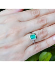1.50 carat Muzo Colombian emerald solitaire ring in 18K white gold on a hand.