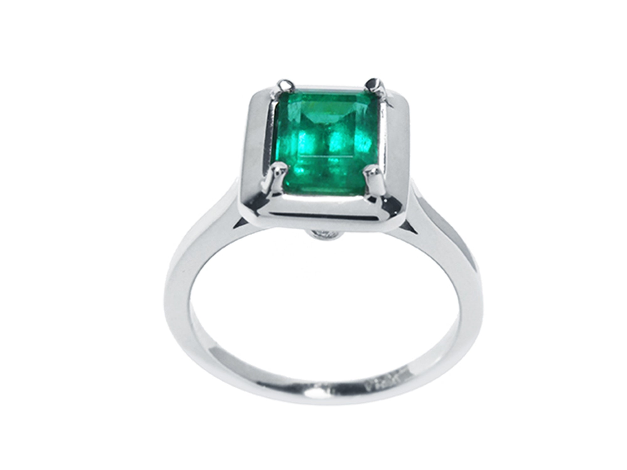 The high-top position of this solitaire emerald ring in white gold shows the profile from the gemstone setting to the band profile.