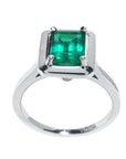 The high-top position of this solitaire emerald ring in white gold shows the profile from the gemstone setting to the band profile.