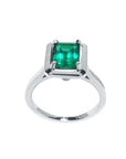The high-top position of this solitaire emerald ring in white gold shows the profile from the gemstone setting to the band profile.