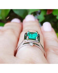 1.50 Carat Muzo Colombian emerald solitaire ring in 18K white gold on a finger.