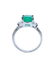 18K white gold ring with a cushion cut emerald and trapezoid side diamonds.