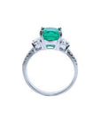 18K white gold ring with a cushion cut emerald and trapezoid side diamonds.