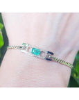 A bracelet with a natural Colombian emerald sourced from the Muzo mines very good quality, made in 14k yellow gold on a wrist.