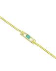 A distant view of a gold bracelet with a genuine emerald on a white background.