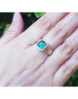 Men's 14K yellow gold ring with a rectangular emerald-cut bluish-green Colombian emerald, bezel set.