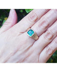 Men's 14K yellow gold ring with a rectangular emerald-cut bluish-green Colombian emerald, bezel set.