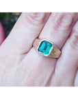 Men's 14K yellow gold ring with a rectangular emerald-cut bluish-green Colombian emerald, bezel set.
