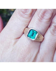 Men's 14K yellow gold ring with a rectangular emerald-cut bluish-green Colombian emerald, bezel set.