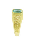 A side position of a yellow gold men's emerald ring showing the top setting and band deign.