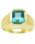 A men's solitaire ring yellow gold with a bezel set natural Muzo mine colombian emerald top and sides perspective view.
