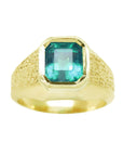 A men's solitaire ring yellow gold with a bezel set natural Muzo mine colombian emerald top and sides perspective view.