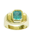 The top profile view of this emerald Muzo mine colombian emerald bezel set solitaire ring for men in yellow gold shows sides design.