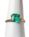 1.28 carat emerald-cut Muzo Mine Colombian emerald in a simple gold ring setting.