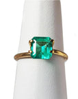 1.28 carat emerald-cut Muzo Mine Colombian emerald in a simple gold ring setting.