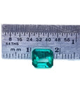 1.28 carat emerald-cut Muzo Mine Colombian emerald, medium deep bluish green, shown with a ruler.