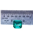 1.28 carat emerald-cut Muzo Mine Colombian emerald, medium deep bluish green, shown with a ruler.