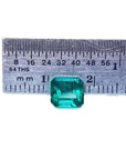 1.28 carat emerald-cut Muzo Mine Colombian emerald, medium deep bluish green, shown with a ruler.