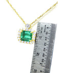 women's Necklace emerald east west orientation encircled in a halo of natural diamonds, crafted in 14k yellow gold