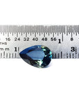 3.22 ct. pear-shaped Australian blue sapphire with deep blue-green hue, shown next to a ruler.