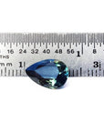 3.22 ct. pear-shaped Australian blue sapphire with deep blue-green hue, shown next to a ruler.