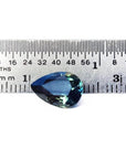 3.22 ct. pear-shaped Australian blue sapphire with deep blue-green hue, shown next to a ruler.