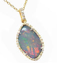 A natural solid Australian opal pendant with a halo diamond on a gold chain, topside view position.