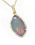 A natural solid Australian opal pendant with a halo diamond on a gold chain, topside view position.