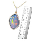 4.30 ct natural Australian opal pendant with fiery red-orange play-of-color, halo diamonds, and 18K yellow gold chain.