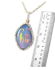 4.30 ct natural Australian opal pendant with fiery red-orange play-of-color, halo diamonds, and 18K yellow gold chain.