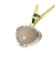 Heart-shaped opal pendant on a gold chain against a white background