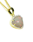 Heart-shaped opal pendant with gold and diamonds frame on a right profile view.