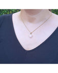Heart-shaped Australian white opal pendant with red fire, diamond halo, on a yellow gold chain.