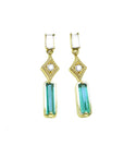 14k yellow gold earrings with baguette cut emeralds dangling from diamonds, front position top view.