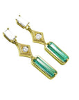 A pair of baguette cut natural emerald and diamond earrings, crafted in 14k yellow gold.