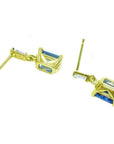 14K yellow gold blue sapphire emerald cut dangle earrings with tapered baguette diamonds.