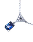Left side of a natural blue sapphire necklace with diamonds dangling pendant top view