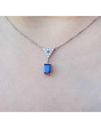 Necklace with a blue sapphire gemstone pendant on a woman's neck
