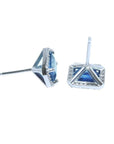 Emerald cut natural blue sapphire stud earrings with diamond halo in 14K white gold.