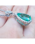 5.83 ct. Colombian emerald pear cut pendant with diamond halo, set in 18K white gold.