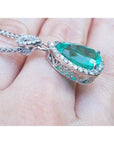 5.83 ct. Colombian emerald pear cut pendant with diamond halo, set in 18K white gold.