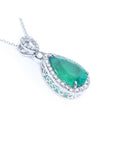 Emerald green teardrop pendant with white gold chain on a right side position topside and gallery visibles.